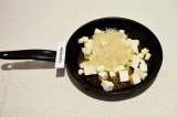 Шаг 3. Выложить на сковороду рис и адыгейский сыр, перемешать и обжаривать пару
