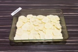 Шаг 5. В форму для запекания выложить два слоя картофельных долек, подсолить.
