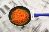 Шаг 4. Морковь натереть на крупной терке, выложить в сковородку, тушить 12-15 ми