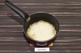 Шаг 5. Добавить в кастрюлю рис и разровнять его по всей поверхности.