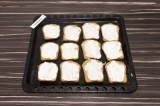 Шаг 6. Ломтики хлеба выложить на противень и смазать сметаной с перцем.